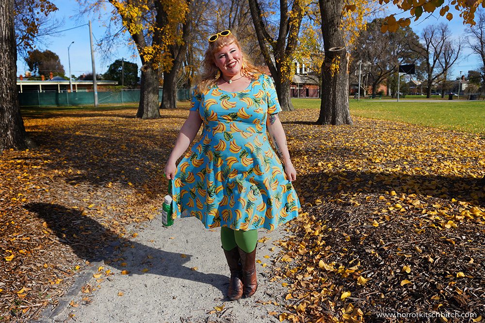 Kobi Jae of plus size fashion blog Horror Kitsch Bitch in a blue vintage-styled retro dress covered in bananas from Lady V London's plus size range - Lady Voluptuous.