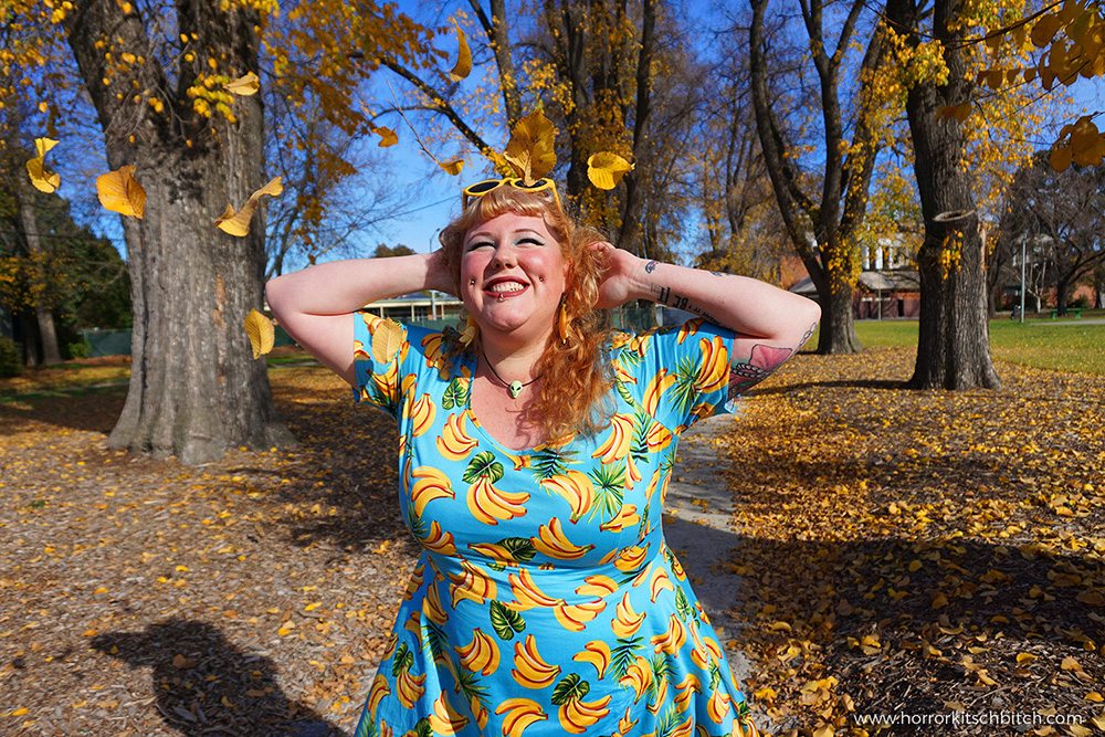 Kobi Jae of plus size fashion blog Horror Kitsch Bitch in a blue vintage-styled retro dress covered in bananas from Lady V London's plus size range - Lady Voluptuous.